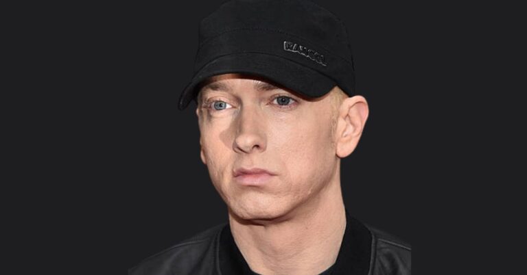 Eminem performing on stage, showcasing his success in music and business.